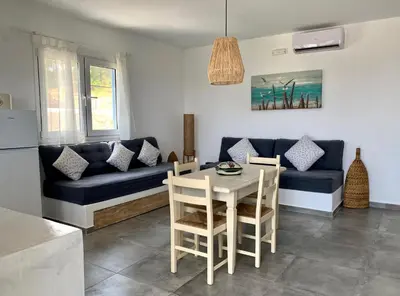 a living room with a blue couch and a table at Anastasia's Garden in Archangelos