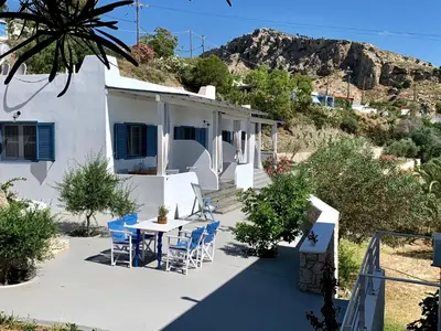a house with a table and chairs on a patio at Anastasia's Garden in Archangelos