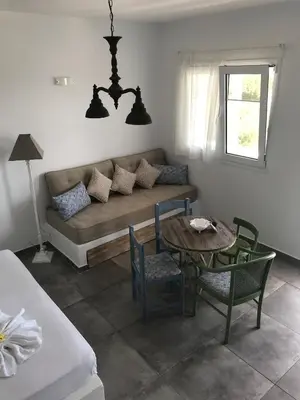 a living room with a couch and a table and chairs at Anastasia's Garden in Archangelos