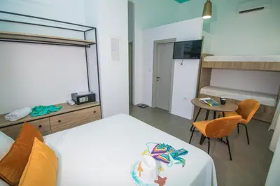 a bedroom with a bed and a desk and a table with chairs at Ialemos Group in Symi