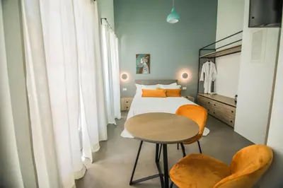 a bedroom with a bed and a table and chairs at Ialemos Group in Symi