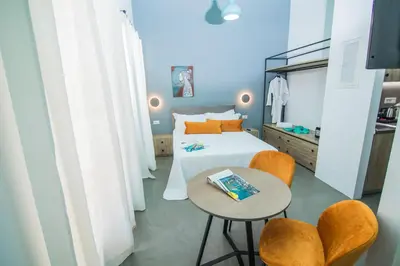 a bedroom with a bed and a table and chairs at Ialemos Group in Symi