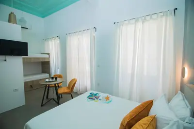 a bedroom with a white bed and a table at Ialemos Group in Symi