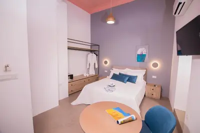 a bedroom with a white bed and a table at Ialemos Group in Symi