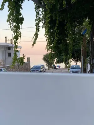 a view of the ocean from a street with cars at Nerea in Archangelos