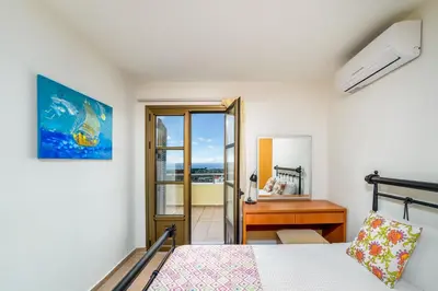 a bedroom with a bed and a desk and a window at Aegean Blue Villa's - All Inclusive & Water park in Kalathos