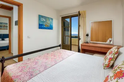 a bedroom with a bed and a desk and a window at Aegean Blue Villa's - All Inclusive & Water park in Kalathos