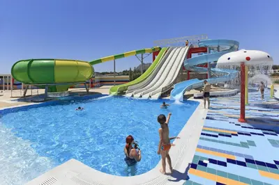 a water park with a slide and people in the water at Aegean Blue Villa's - All Inclusive & Water park in Kalathos