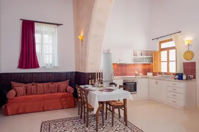 a kitchen with a table and a red couch at Villa Amalia in Líndos
