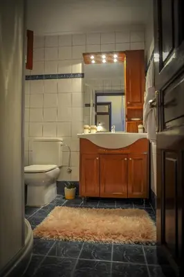 a bathroom with a tub and a toilet and a mirror at Villa Amalia in Líndos