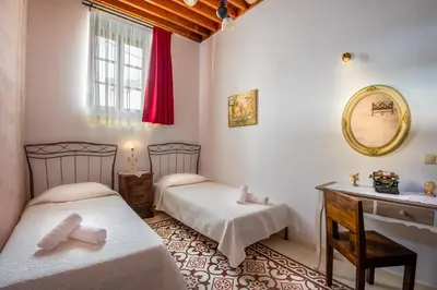 a bedroom with two beds and a vanity and a mirror at Villa Amalia in Líndos