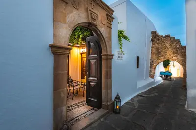 an archway in a white building with a door at Villa Amalia in Líndos
