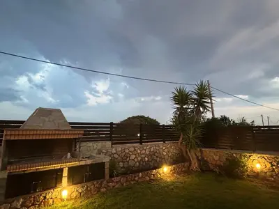 a house with a stone wall with lights on it at Villa Poseidon Blue in Rhodes Town