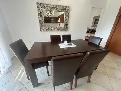 a dining room table with chairs and a mirror at Villa Poseidon Blue in Rhodes Town