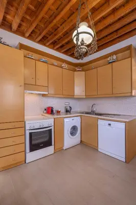 a kitchen with white appliances and wooden cabinets at Filigrana Villa Lindos in Líndos