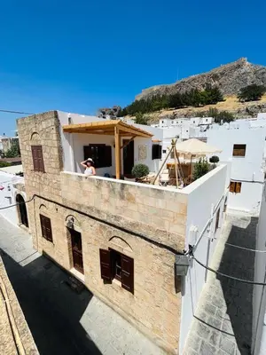 a man standing on a balcony of a building at Filigrana Villa Lindos in Líndos