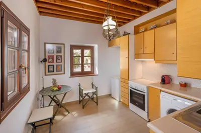 a kitchen with a table and a small table with chairs at Filigrana Villa Lindos in Líndos