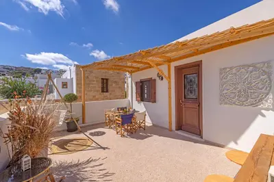 a patio with a door and a table and chairs at Filigrana Villa Lindos in Líndos