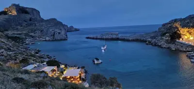 a large body of water with two boats in it at Lindos Luxury Belfry Apartment in Líndos