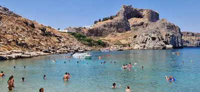 a group of people swimming in a body of water at Lindos Luxury Belfry Apartment in Líndos