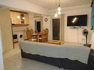 a living room and kitchen with a couch and a table at Periklis House in Ixia