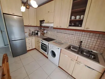 a kitchen with a refrigerator and a washing machine at Periklis House in Ixia