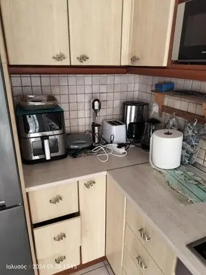 a kitchen with wooden cabinets and a counter top at Periklis House in Ixia
