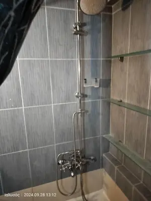 a shower with a glass door in a bathroom at Periklis House in Ixia