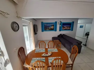 a dining room table and chairs in a living room at Periklis House in Ixia