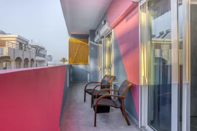 a balcony with two chairs and a wall at Aletreo, Rhodes in Rhodes Town