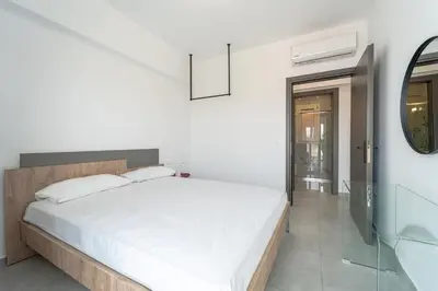 a bedroom with a white bed and a mirror at Aletreo, Rhodes in Rhodes Town