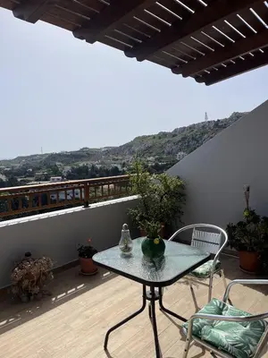 a table and chairs on a balcony with a view at Sea View Loft in Koskinou