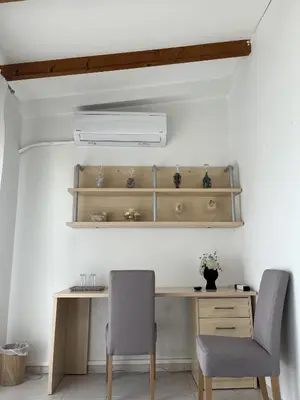 a desk and two chairs in a room at Sea View Loft in Koskinou