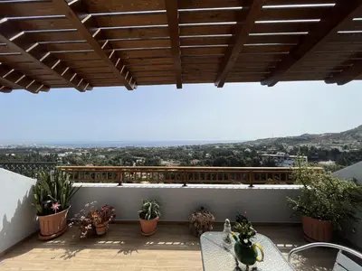 a balcony with potted plants and a wooden roof at Sea View Loft in Koskinou