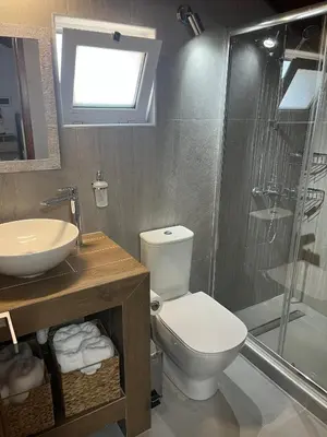 a bathroom with a toilet and a sink and a shower at Sea View Loft in Koskinou