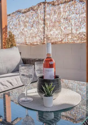 a bottle of wine and two glasses on a table at Cozy Loft with Private Terrace in Kremasti