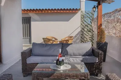 a wicker couch and a table on a patio at Cozy Loft with Private Terrace in Kremasti