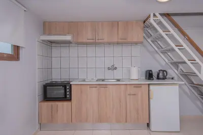 a kitchen with wooden cabinets and a microwave at Cozy Loft with Private Terrace in Kremasti