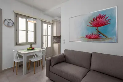 a living room with a couch and a table at cattleya suite lindos in Líndos
