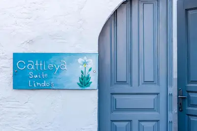 a blue door and a sign next to a door at cattleya suite lindos in Líndos