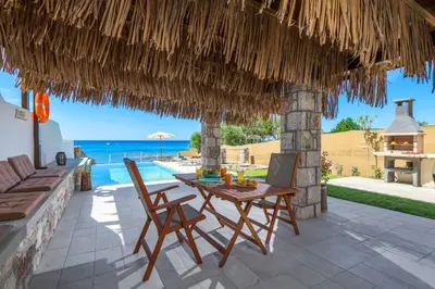 a patio with a table and chairs and the ocean at Anima Maris in Kiotari