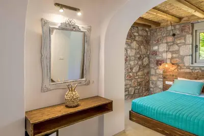 a bedroom with a bed with a mirror and a table at Anima Maris in Kiotari