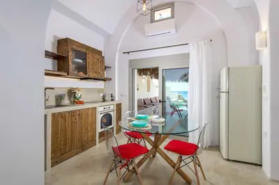 a kitchen with a glass table and chairs and a refrigerator at Anima Maris in Kiotari