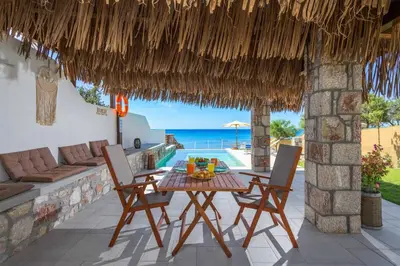 a patio with a table and chairs and the ocean at Anima Maris in Kiotari