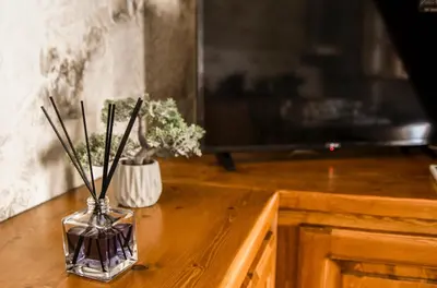 a vase with flowers in it on a wooden table at Stone Living Symi Central Apartments in Symi