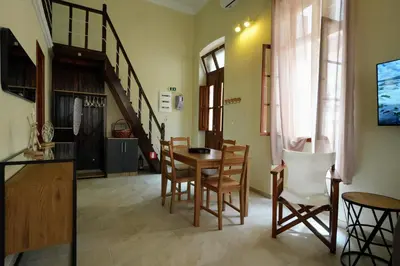 a kitchen and dining room with a table and chairs at Stone Living Symi Central Apartments in Symi