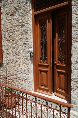 a wooden door on the side of a building at Stone Living Symi Central Apartments in Symi