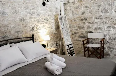 a bedroom with a bed with a teddy bear on it at Stone Living Symi Central Apartments in Symi