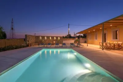 a swimming pool in a backyard with a house at Villa Dorinna in Lachania