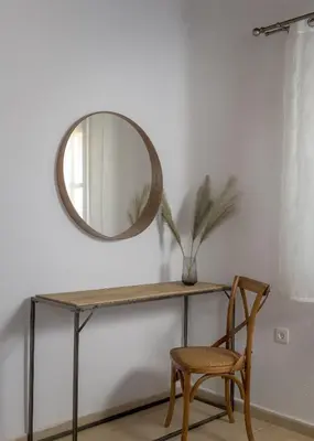 a mirror and a chair in a room with a table at Villa Dorinna in Lachania